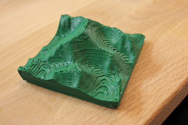 A small green 3D-printed model of Mt. Everest