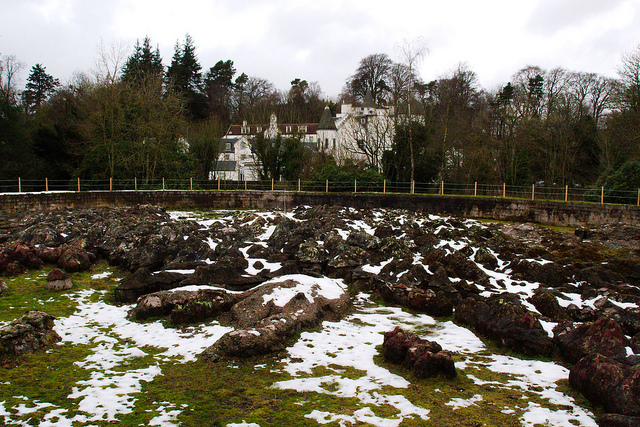 A huge map of Scotland made of snow-covered concrete chunks in a field